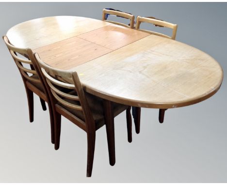 A 20th century oval teak G-Plan extending dining table and four ladder back chairs 