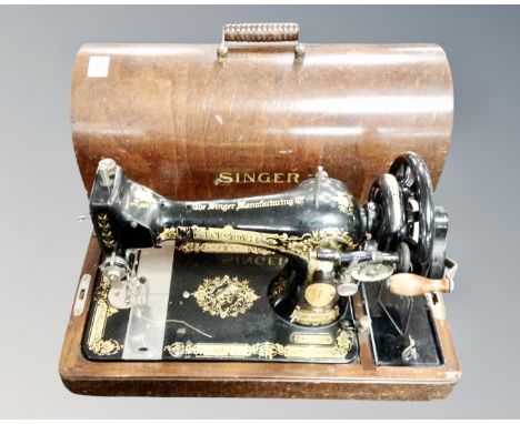 A vintage Singer hand sewing machine in case.