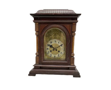 A Junghans two train mantle clock with a subsidiary third chiming train, in a mahogany and oak case with a concave raised top