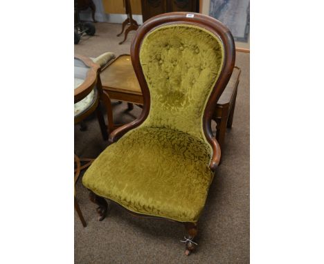 A Victorian walnut and green upholstered nursing chair, the button back and padded seat raised on cabriole legs with whorl fe