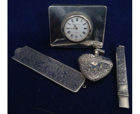 A silver pencil case; silver covered comb; both with feather scroll engraving; a Tiffany &amp; Co silver mounted bedside cloc