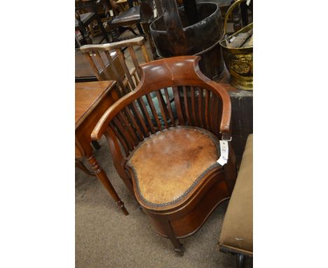 A 19th Century mahogany commode chair, with shaped seat upholstered in brown leather, raised on brass castors.