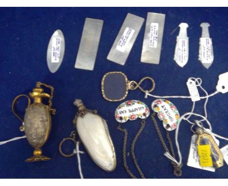 Objects of vertu, including: a scent bottle; Chinese mother-of-pearl gaming tokens; an eye glass; and enamel decanter labels.
