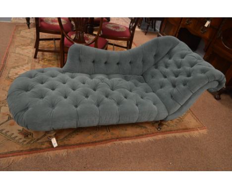 An early 20th century reupholstered chaise lounge, with undulating back and scroll over end, with deep button back and seat r