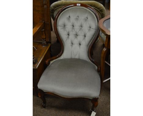 A Victorian mahogany framed nursing chair, with button back and padded seat raised on cabriole legs and terminating in whorl 