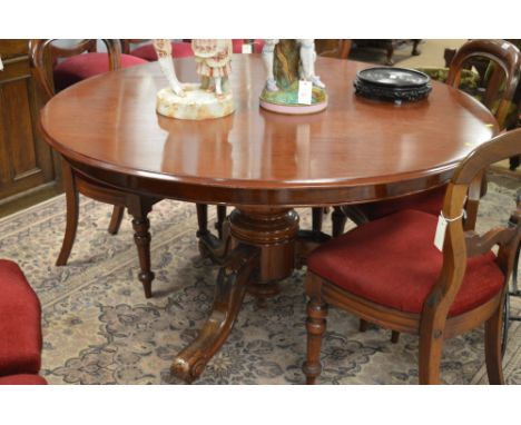 A Victorian mahogany breakfast table with moulded edge above a central baluster turned column and raise on outswep scroll leg