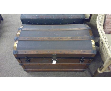 A 20th century oak and brass bound domed trunk, the domed and hinged top enclosing an interior, with oak strengthening bars a