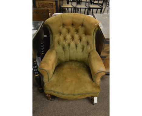 A Victorian easy armchair, with scrolled toprail and button back and sides and raised on tunred and tapering legs terminating