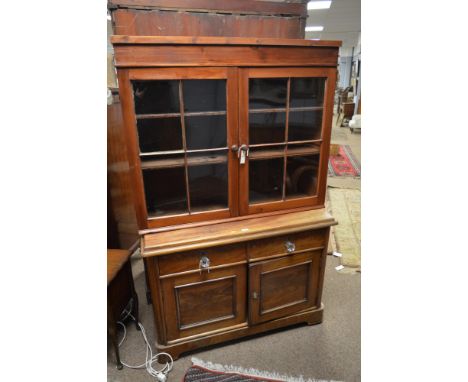 A 20th century mahogany dresser base with an associated pine bookcase top. the top with two astragal glazed doors enclosing t