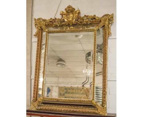 WALL MIRROR, 19th century French giltwood and gesso, circa 1880, of cushion form with a shield surmount and bevelled central 