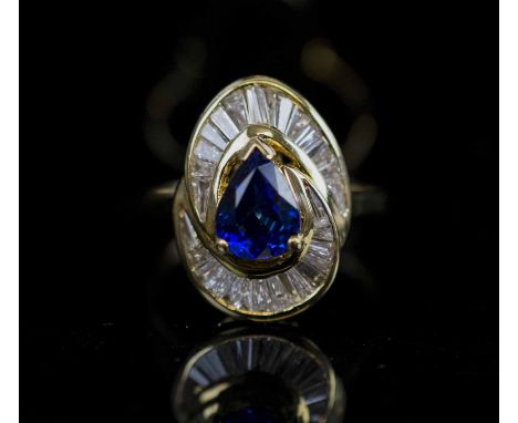 A SAPPHIRE AND DIAMOND RING, the pear shaped sapphire centre stone weighing approx 1.06 carats within a calibre cut baguette 