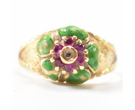 An 18ct gold, ruby and enamel dome flower ring. The ring having a floral motif made up of six round cut claw set ruby to emul