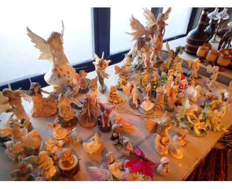 Shelf full of fairy figurines various sizes 