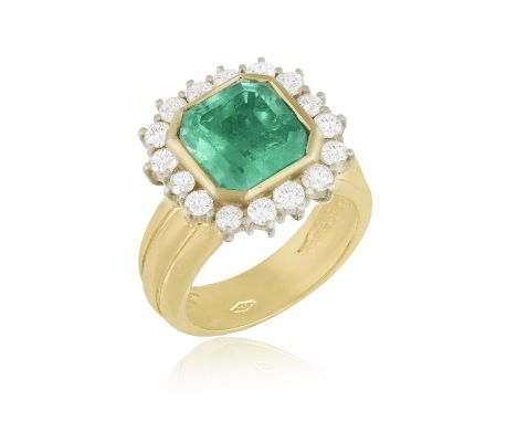 AN EMERALD AND DIAMOND DRESS RING, the octagonal-cut emerald within a surround of brilliant-cut diamonds, mounted in 18K gold