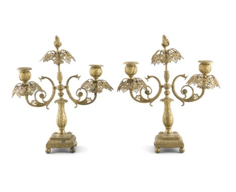 A PAIR OF LATE 19TH CENTURY ORMOLU TWO LIGHT CANDLEABRAthe scroll arms raised above a leaf decorated baluster column on a squ