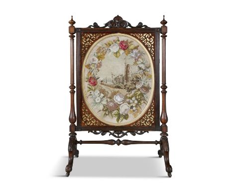 A LARGE VICTORIAN WALNUT FRAMED TAPESTRY FIRE SCREEN the oval needle work panel enclosed within a fret work surround supporte