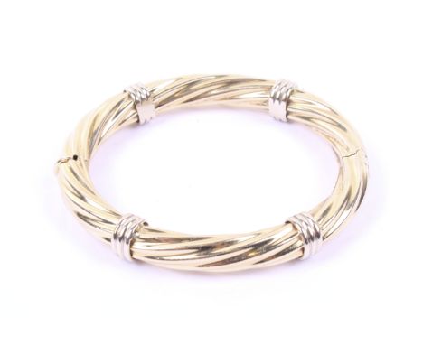An Italian spiral fluted hollow hinged bangle. In yellow with four white fluted bands and a push snap stamped '585 Italy', 8.