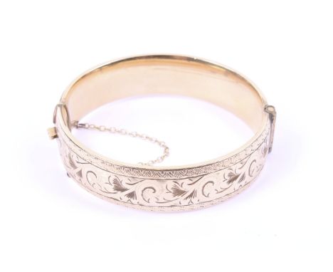 A vintage gold-plated part foliate engraved broad hinged bangle. Stamped '1/5 9ct metal core', 15.7mm wide 
