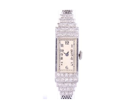 A vintage lady's platinum and diamond wrist watch on a 9ct white gold bracelet, circa 1961. The rectangular silvered dial wit