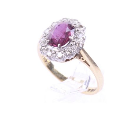 A vintage 18ct gold, ruby and diamond oval cluster ring. Centred with an oval mixed-cut ruby within an eight-cut diamond twel