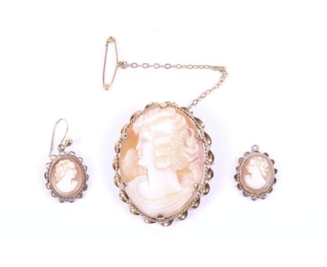A vintage 9ct gold and oval shell cameo brooch and a pair of similar pendent earrings. Each depicting an unknown female profi