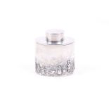A silver oval tea caddy embossed with figures in a pastoral landscape.