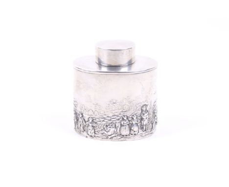 A silver oval tea caddy embossed with figures in a pastoral landscape. With a plain pull-off cover, mark of Nathan and Hayes,