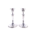 A pair of Edwardian silver oval candlesticks.