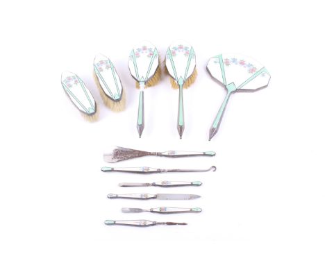 A George V silver and enamel mounted piece dressing table set. Comprising; two hair brushes, two clothes brushes, a hand mirr