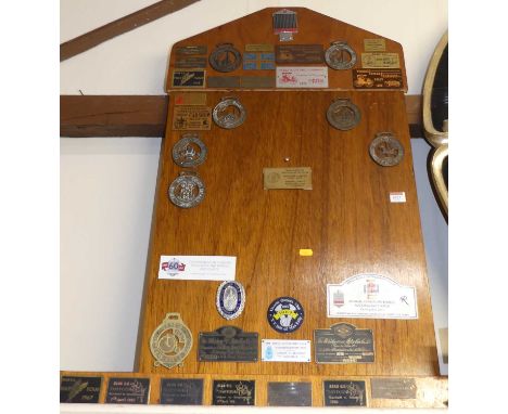 An oak noticeboard containing assorted motoring interest enamel and brass badges, 96 x 54cm; together with three other smalle