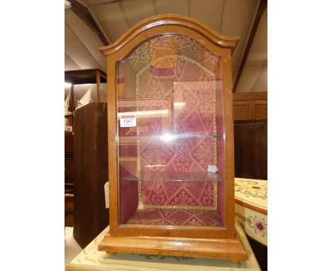 A small early 20th century oak and arched single door glazed table top curiosity display cabinet, 46 x 27.5cm