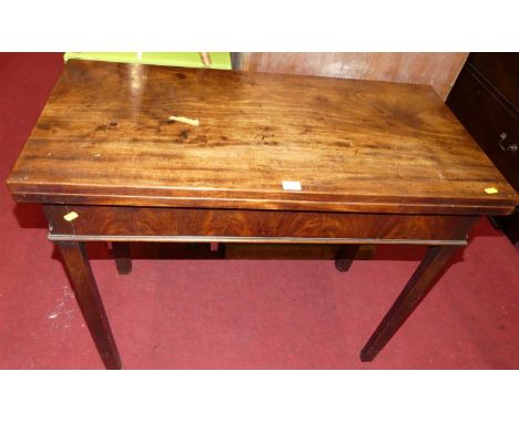 A George III mahogany fold-over tea table, raised on chamfered square supports, width 91.5cm