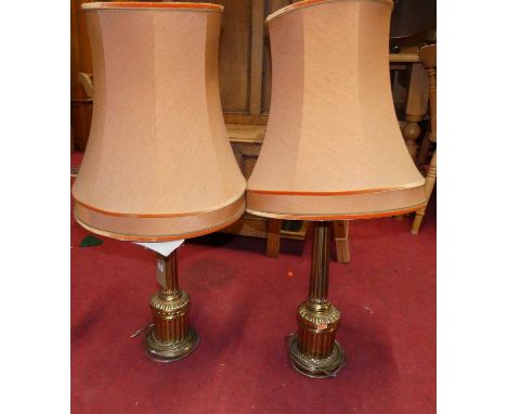 A pair of fluted brass table lamps in the classical taste, each with shades