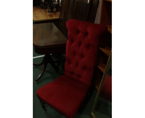 Victorian prie-dieu chair, upholstered in a red fabric with button back, on turned legs and castors