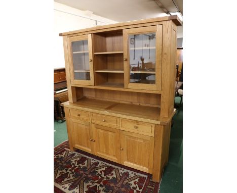 Light oak dresser, with central shelves flanked by two glazed cupboards, the base with three frieze drawers and three panelle