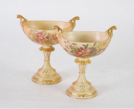 PAIR OF EARLY TWENTIETH CENTURY ROYAL WORCESTER BLUSH PORCELAIN TWO HANDLED PEDESTAL DISHES, of boat form with knopped pedest