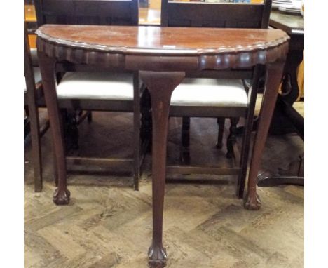 A mahogany semi-circular console table standing on claw and ball feet 3' wide 