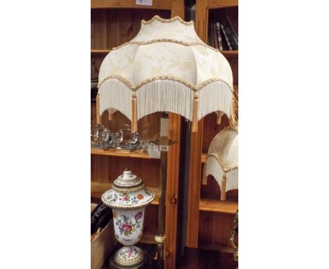A brass cherub decorated Corinthian column standard lamp with cream patterned fringed shade 