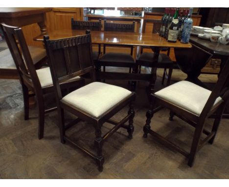 An Ercol oak refectory style dining table together with four oak panel backed dining chairs and two others 