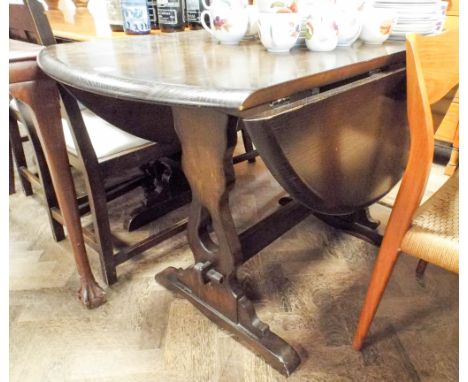 An Ercol dark oak refectory style drop leaf dining table 4' wide 