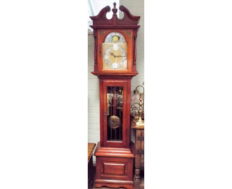 A reproduction Grandfather clock with arched moon face dial with striking movement and chiming movement in a mahogany and gla