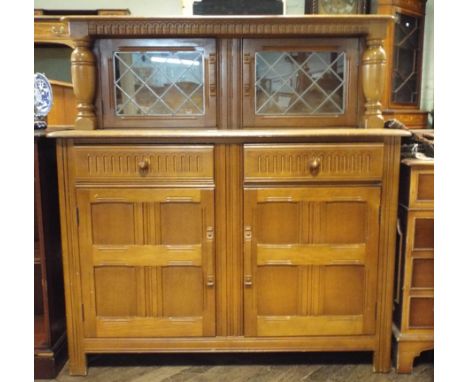 An Ercol oak sideboard with low leaded glazed back, drawers and cupboards under 4' wide 