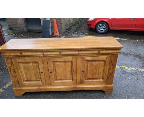 A modern French style oak sideboard with three drawers and three doors, on bracket feet, 198cm long, 103 high, 52 deep. A mod