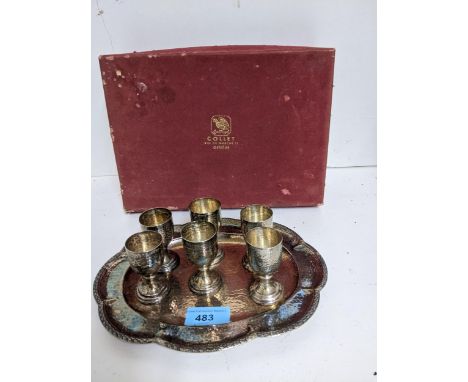 A white metal set of six liqueur goblets on a shaped oval tray, hammered decoration, stamped marks R Suiza 0.900, in a Collet