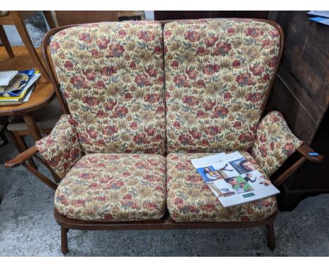 Ercol dark oak cottage three piece suite compromising two seater sofa and two matching armchairs with detachable floral patte