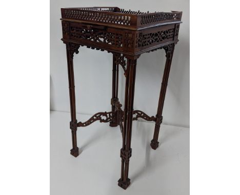 A late 19th/early 20th century mahogany kettle stand in the Chippendale style having pierced fretwork, triple cluster column 
