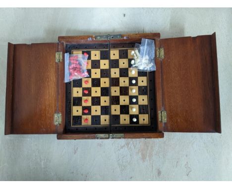 A Victorian mahogany travelling chess set, the folding board with red and white plastic chess pieces Location: 