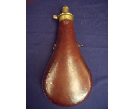 Large bodied brown leather cupboard powder flask of typical swollen bag shape with brass dispensing mounts, the body stamped 