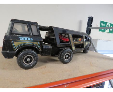 A vintage metal Tonka car transporter containing two Tonka cars 