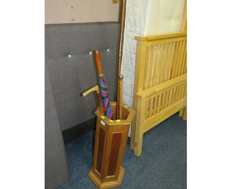 A vintage hexagonal stick stand with assorted sticks to include a hallmark silver top cane 